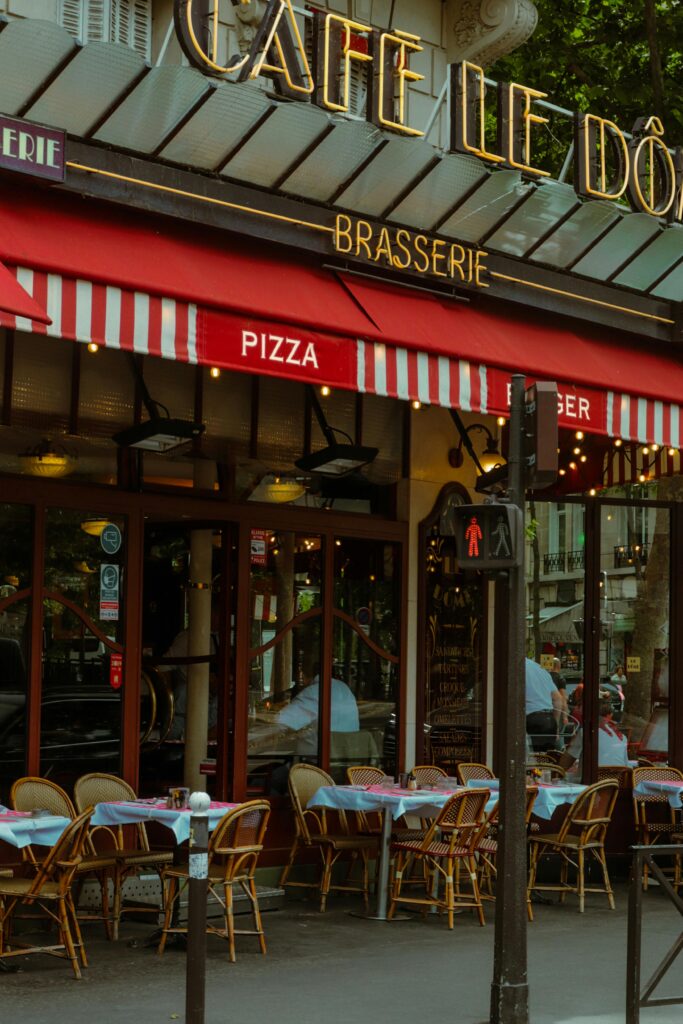 A traditional Parisian café with outdoor seating on a bustling street in Paris, France.